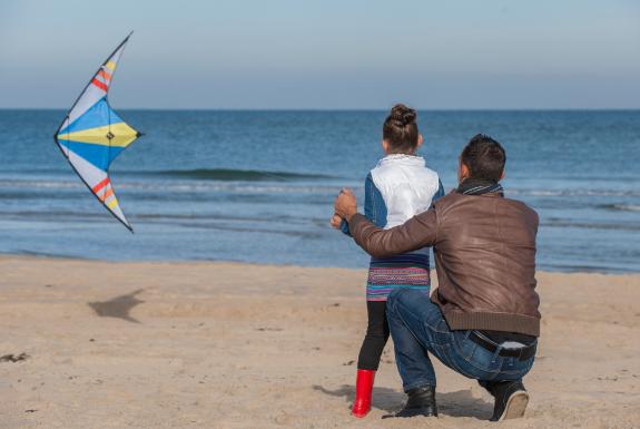 Vater und Tochter, die einen Drachen fliegen | Beach Resort Nieuwvliet-Bad